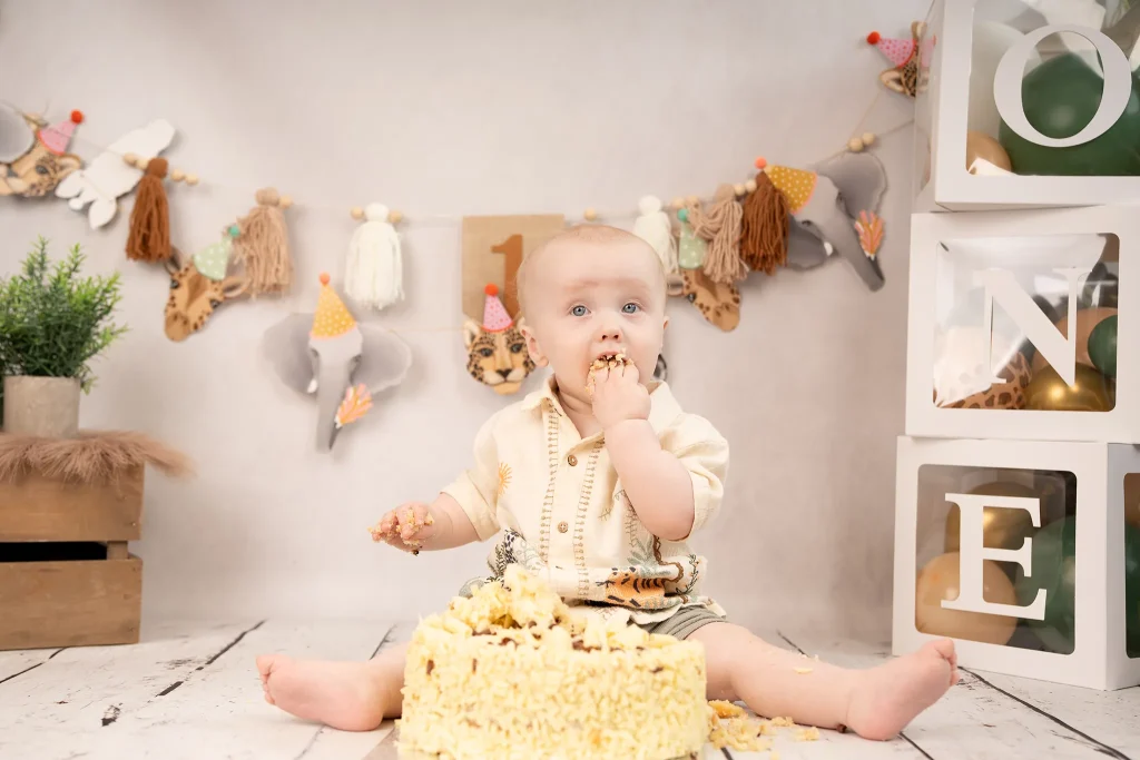 Baby eating cake at cake smash shoot in Preston studio