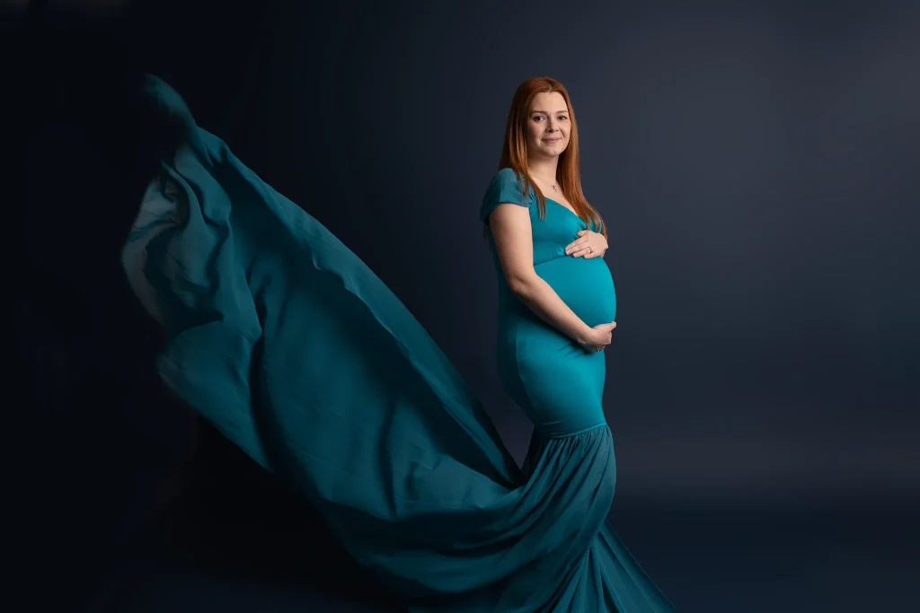 Pregnant lady in green holding bump