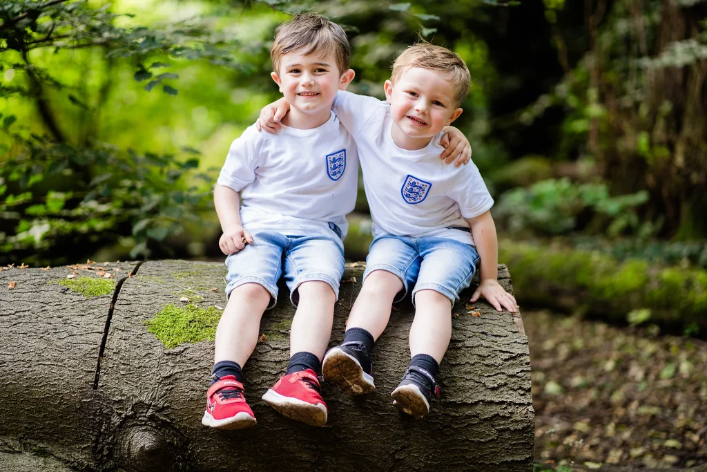 Two brothers sat on logg hugging