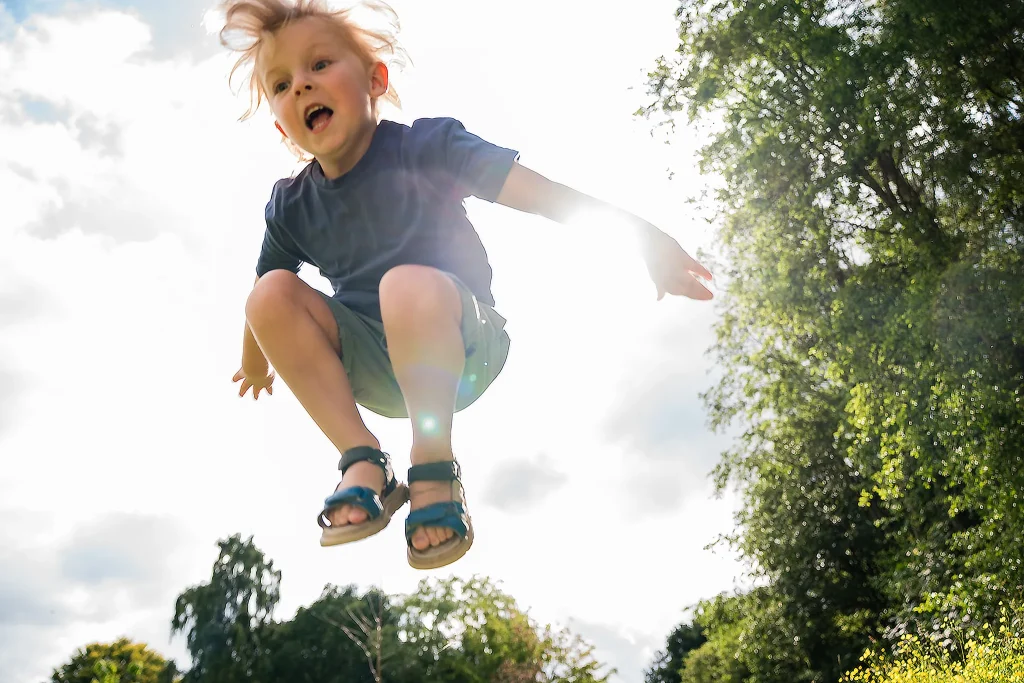 Boy jumping over camera on family photo shoot